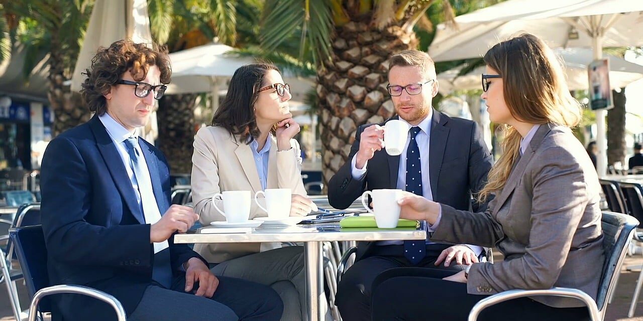 two men and two women and outdoor meeting with coffee